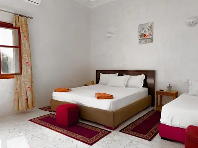 a bedroom with two beds and a window at Guest House Qodwa in Marrakech