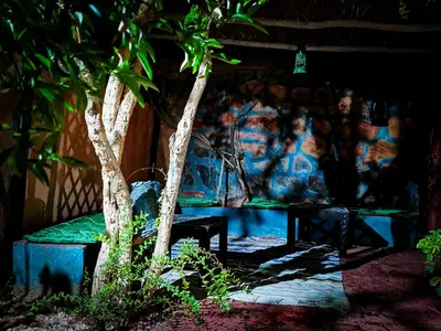 a room with a bench between two trees at Riad Dar Zaouia in Zagora