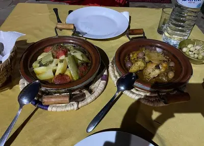 two bowls of food sitting on a table with spoons at Maggaman Guest House in Tafraoute Sidi Ali
