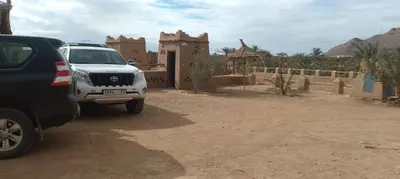 a white suv parked in front of a building at Maggaman Guest House in Tafraoute Sidi Ali