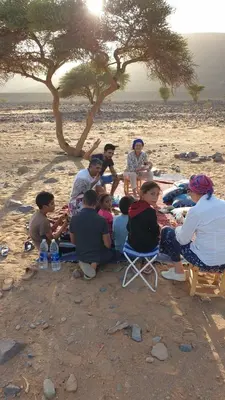 a group of people sitting on the beach at Maggaman Guest House in Tafraoute Sidi Ali