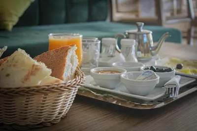a breakfast tray with bread and a basket of orange juice at HOTEL CAFE PALAIS SALAM , Beni Mellal in Beni Mellal