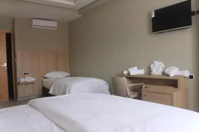 a hotel room with two beds and a television at HOTEL CAFE PALAIS SALAM , Beni Mellal in Beni Mellal
