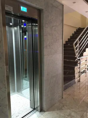a glass elevator in a building with a staircase at HOTEL CAFE PALAIS SALAM , Beni Mellal in Beni Mellal