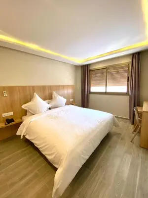 a bedroom with a large white bed with a window at HOTEL CAFE PALAIS SALAM , Beni Mellal in Beni Mellal