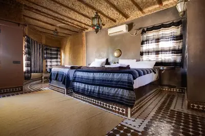 a bedroom with a large bed in a room at Hotel ksar merzouga in Merzouga