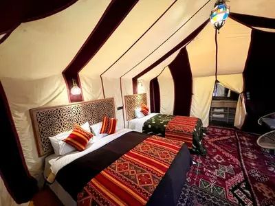 a bedroom with two beds in a tent at Hotel ksar merzouga in Merzouga