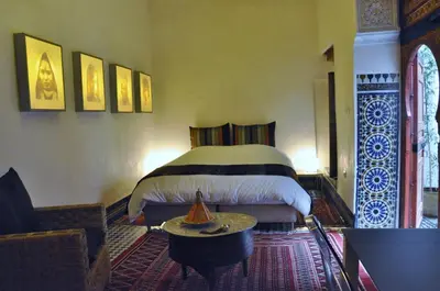 a bedroom with a bed and a table in a room at Dar 7 Louyat in Fès