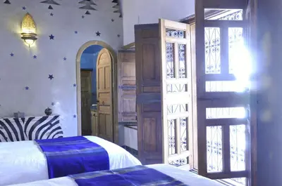 a bedroom with a bed and an open door at Dar 7 Louyat in Fès