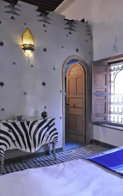 a zebra bed in a room with a wall with stars at Dar 7 Louyat in Fès