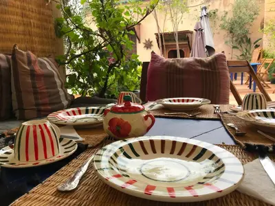 a table with plates and utensils on top of it at Dar 7 Louyat in Fès