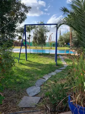 a swing set in front of a swimming pool at villa Marrakech raja in Marrakech