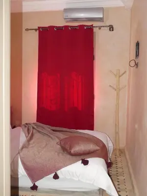 a bedroom with a red curtain and a bed at Dar Diafa Chez Anaam in Er Rachidia