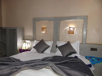 a bedroom with a large white bed with pillows at Dar Diafa Chez Anaam in Er Rachidia