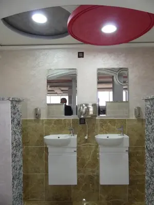 a bathroom with two sinks and two mirrors at Dar Diafa Chez Anaam in Er Rachidia