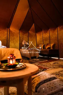 a room with a couch and a table in a tent at Merzouga White Camp - Official Luxury Camp in Merzouga