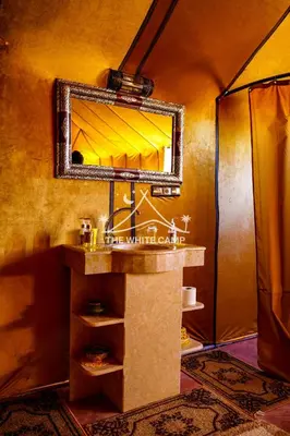 a bathroom with a sink and a mirror at Merzouga White Camp - Official Luxury Camp in Merzouga