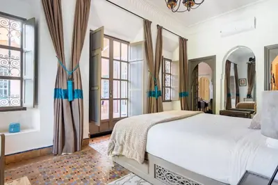 a bedroom with a large bed and windows at Villa Pauline with private pool & jacuzzi, hotel service and no insight in Marrakech