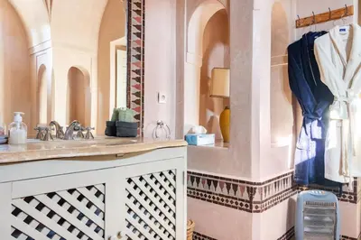 a bathroom with a sink and a mirror at Villa Pauline with private pool & jacuzzi, hotel service and no insight in Marrakech