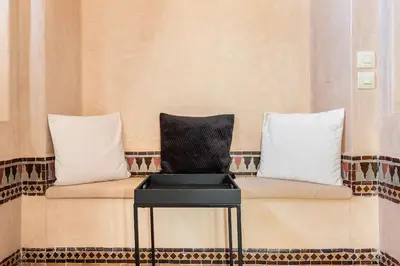 a chair sitting on a bench with a piano at Villa Pauline with private pool & jacuzzi, hotel service and no insight in Marrakech