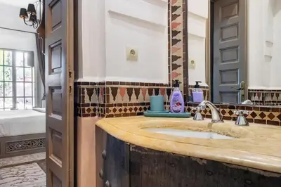 a bathroom with a sink and a mirror at Villa Pauline with private pool & jacuzzi, hotel service and no insight in Marrakech
