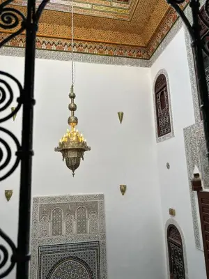 a chandelier hangs in a room with a mosque at Riad Fes Colors & SPA - Family Lodging in Fès
