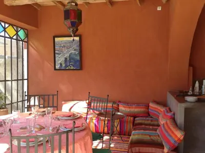 a dining room with a table and chairs and a window at RIAD CHANT D'ETOILES tadighoust in El Hara