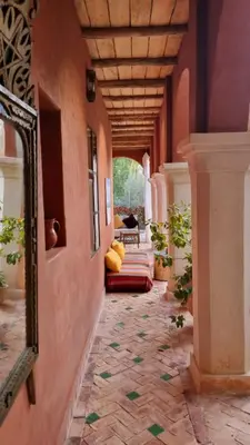 a hallway of a house with a mirror and a couch at RIAD CHANT D'ETOILES tadighoust in El Hara