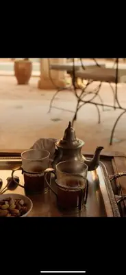 a tea kettle and two cups on a stove at RIAD CHANT D'ETOILES tadighoust in El Hara