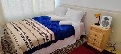 a small bedroom with a bed and a night stand at Auberge IMIN TAGHYA in Akhendachou nʼAït Ouffi