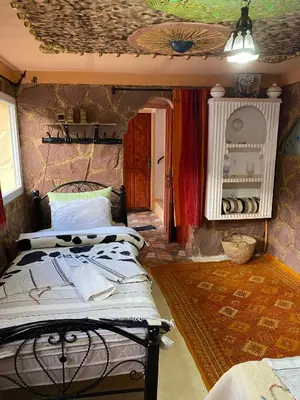 a bedroom with two beds in a room with a ceiling at Auberge IMIN TAGHYA in Akhendachou nʼAït Ouffi