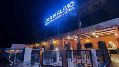 a sign on the side of a building at night at Dar Ikalimo Ourika in Aghbalou