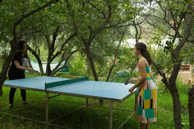 two women playing ping pong on a ping pong table at Dar Ikalimo Ourika in Aghbalou