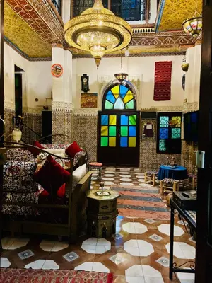 a room with a couch and stained glass windows at Riad Abqari Youssefi in Fès