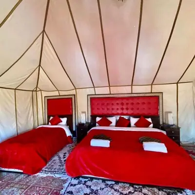 a bedroom with two beds in a tent at Authentic Luxury Camp in Merzouga
