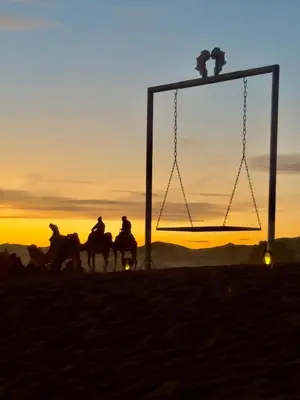 a group of people riding horses in the sunset at Authentic Luxury Camp in Merzouga