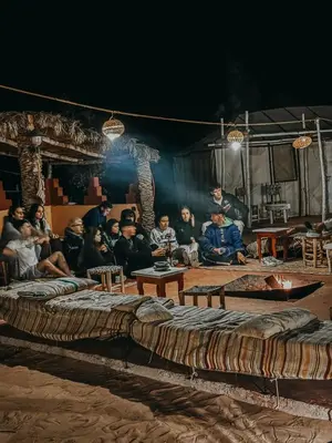 a group of people sitting in a room with large beds at Authentic Luxury Camp in Merzouga