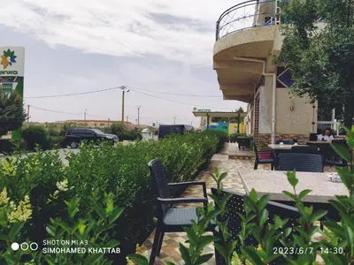 a patio with chairs and a building with a balcony at Chalets ITO Atlas Timnay in Midelt