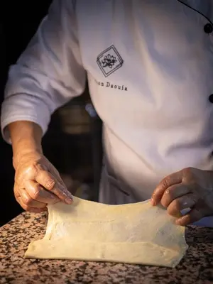 a chef is shaping a piece of pizza dough at Maison Daouia in Marrakech