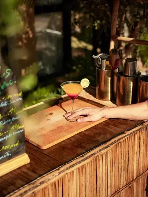 a woman holding a drink on a wooden counter at Maison Daouia in Marrakech