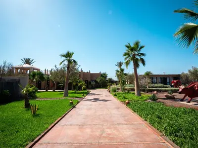 a walking path in a park with palm trees at Maison Daouia in Marrakech