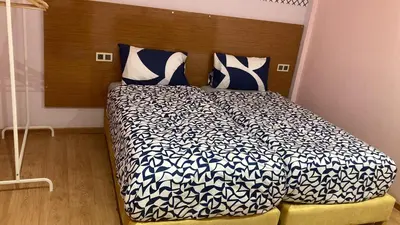 a bedroom with a bed with a black and white comforter at FIFI maison in Ouarzazate