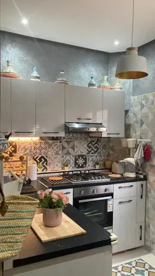 a kitchen with white cabinets and a stove top oven at FIFI maison in Ouarzazate