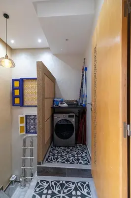 a laundry room with a washer and a tile floor at FIFI maison in Ouarzazate