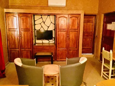 a living room with chairs and a table and a tv at Riad ait Ben Haddou in Aït Ben Haddou