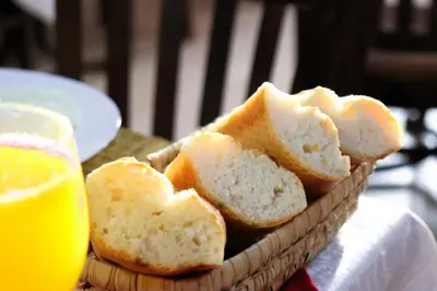 a basket of bread and a glass of orange juice at Riad ait Ben Haddou in Aït Ben Haddou