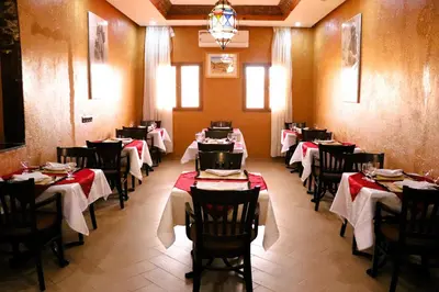 a dining room with tables with red and white tablecloths at Riad ait Ben Haddou in Aït Ben Haddou