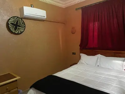 a bedroom with a bed with a air conditioner on the wall at Riad ait Ben Haddou in Aït Ben Haddou