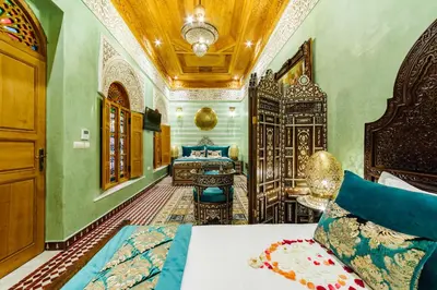 a bedroom with a bed and a vanity in a room at Riad Rcif Alif Suite & SPA in Fès