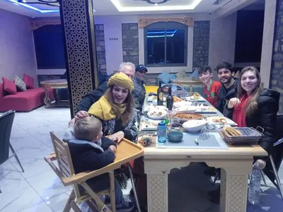a group of people sitting at a table eating food at Relais Des Nomades in Tinerhir